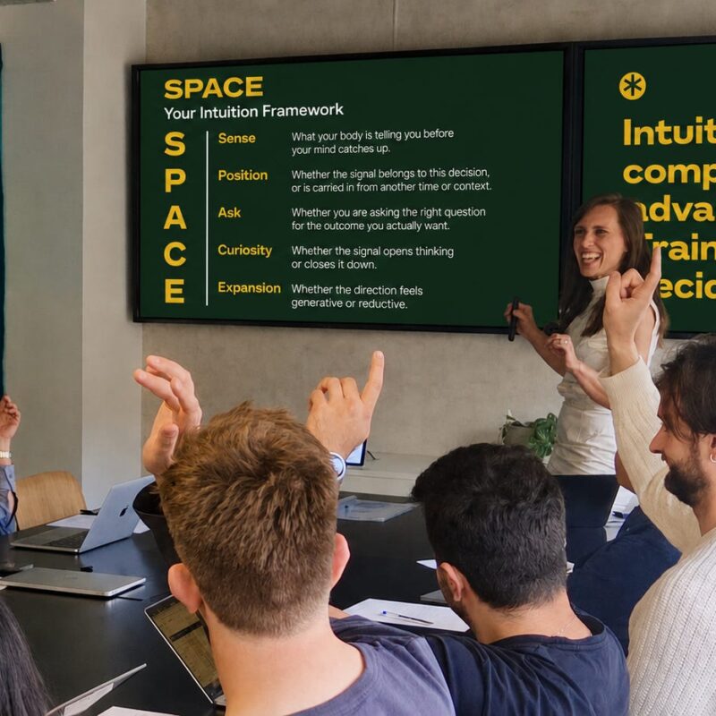Livia Bernardini presenting the SPACE intuition framework to a team workshop, with participants raising their hands around the table